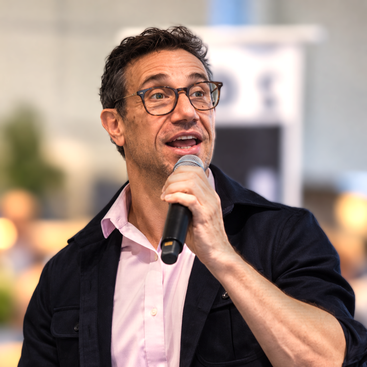 John Westworth speaking into a microphone at an event